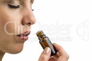 Close-up of female patient smelling medicine bottle