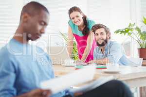 Portrait of business people at desk with person sitting on foreg