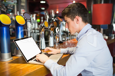 Man using laptop at bar counter