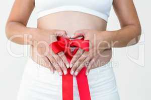 Pregnant woman with a red ribbon around her bump