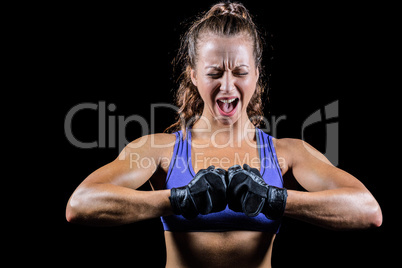 Aggressive female boxer flexing muscles