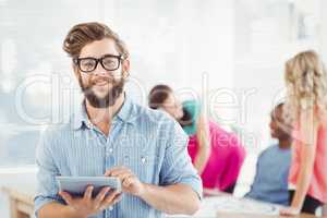 Portrait of smiling man wearing eyeglasses using digital tablet