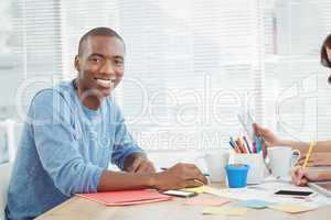 Portrait of smiling man while working at desk