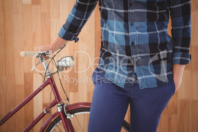 Mid section of hipster with bicycle