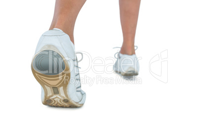 Low section of woman wearing sports shoe jogging