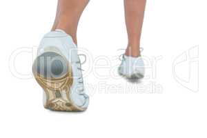 Low section of woman wearing sports shoe jogging