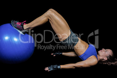 Side view of woman exercising with ball