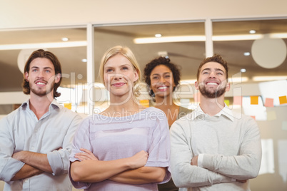 Smiling creative team with arms crossed in office