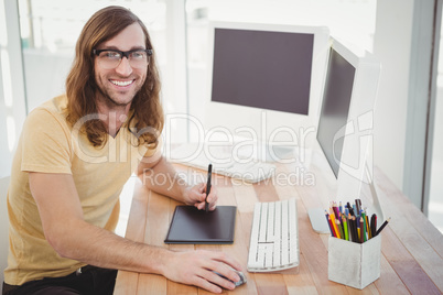 Portrait of happy hipster with graphics tablet