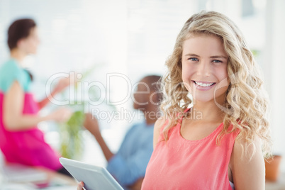 Portrait of happy woman while holding digital tablet
