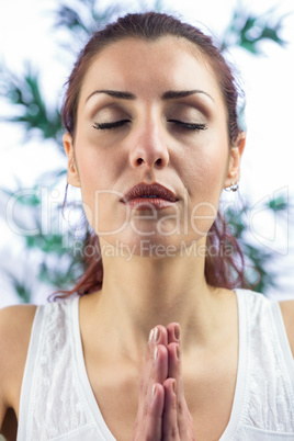 Calm woman with eyes closed and hands joined