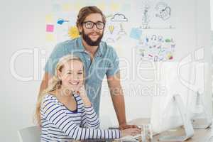 Portrait of smiling business people at computer desk