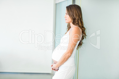 Side view of pregnant woman standing in room