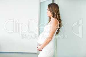 Side view of pregnant woman standing in room