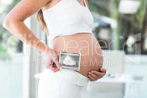 Side view of woman holding sonogram