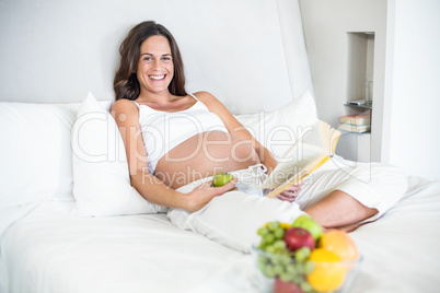 Portrait of happy woman with novel and Granny Smith