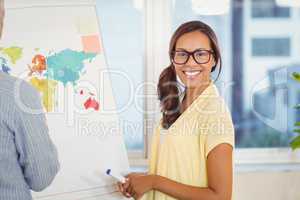 Businesswoman with male colleague standing near world map on whi
