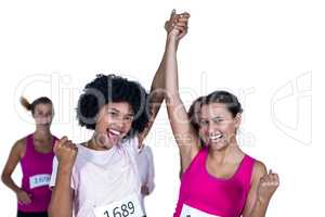 Portrait of smiling winner athletes with arms raised