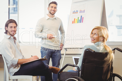 Confident business people with whiteboard during meeting