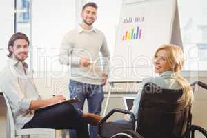 Confident business people with whiteboard during meeting