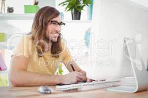 Happy hipster at computer desk