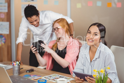 Businesswoman holding digital tablet with colleagues