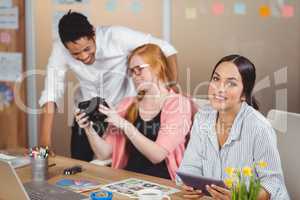 Businesswoman holding digital tablet with colleagues