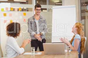 Female colleagues appreciating businessman in meeting