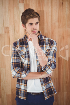 Confident hipster standing with hand on chin