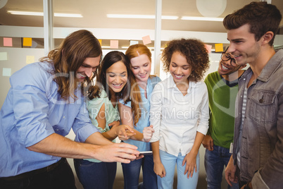 Businessman showing phone to happy colleagues