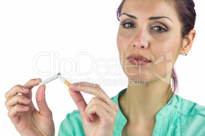 Close-up portrait of woman breaking cigarette