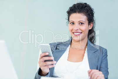 Smiling businesswoman using smart phone