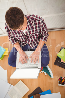 Hipster working on laptop in office