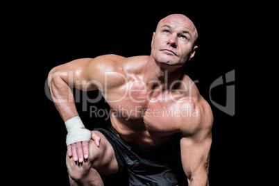 Bodybuilder exercising against black background