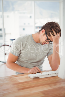 Frustrated hipster sitting at computer desk