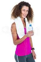 Portrait of happy young woman with towel holding bottle