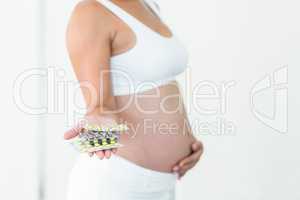 Pregnant woman holding vitamin pills
