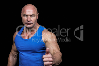 Portrait of confident muscular man showing thumbs up