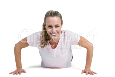 Portrait of happy fit woman doing push ups