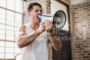 Muscular man talking through megaphone