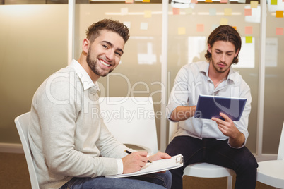 Portrait on smiling businessman with male colleague