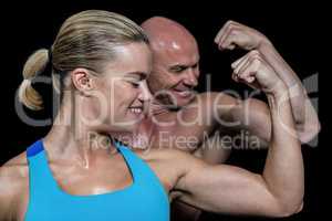 Happy healthy man and woman flexing muscles