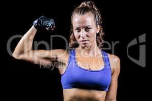 Portrait of confident woman flexing muscles