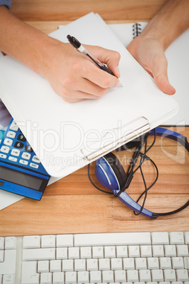 Businessman writing in paper on clipboard