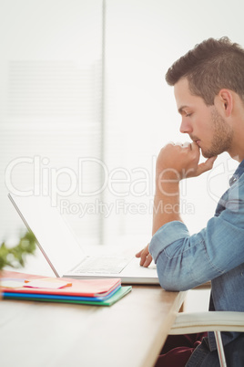 Thoughtful young man using laptop