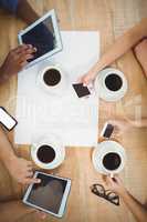 Close-up of people using technology at desk