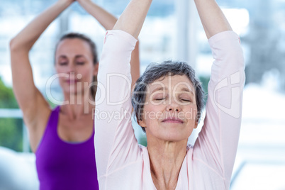 Women meditating with joined hands and eyes closed