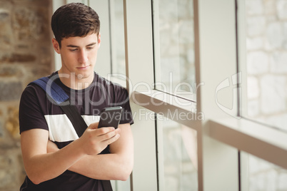 Male student using mobile phone in college