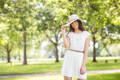 Portrait of confident smiling woman holding sun hat