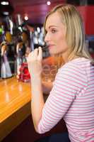 Young woman sipping drink at bar counter